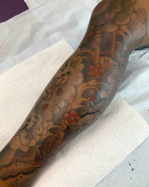 A Japanese-style color sleeve of clouds, waves and cherry blossoms on darker skin, by Shannon Moxie