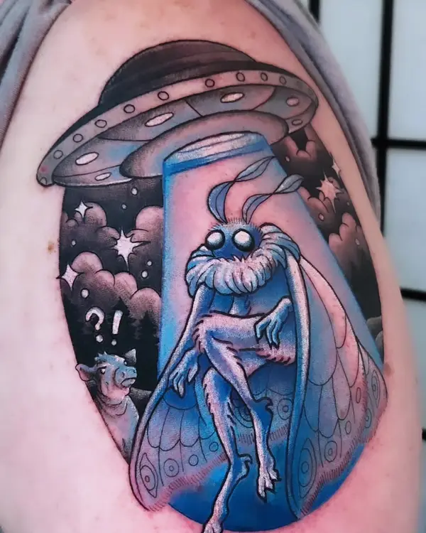 A color tattoo of a blue moth in a beam of light under a UFO, with a small blue cow looking on, by Amanda Boyd