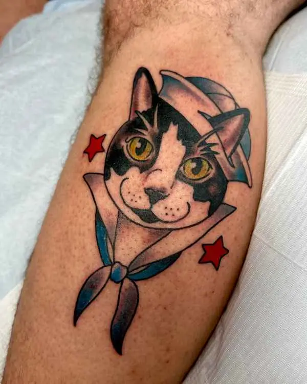 A neo-traditional tattoo of a black and white cat in a sailor hat and neckerchief with red stars, by Betty Rose