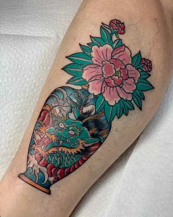 Japanese-style dragon painted on a vase on the calf, with a pink peony and buds growing out of the top.