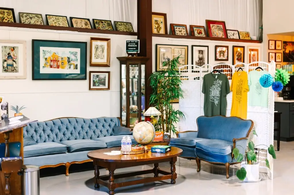 The waiting room at Rose and Crown Tattoos, with sofas and framed artwork