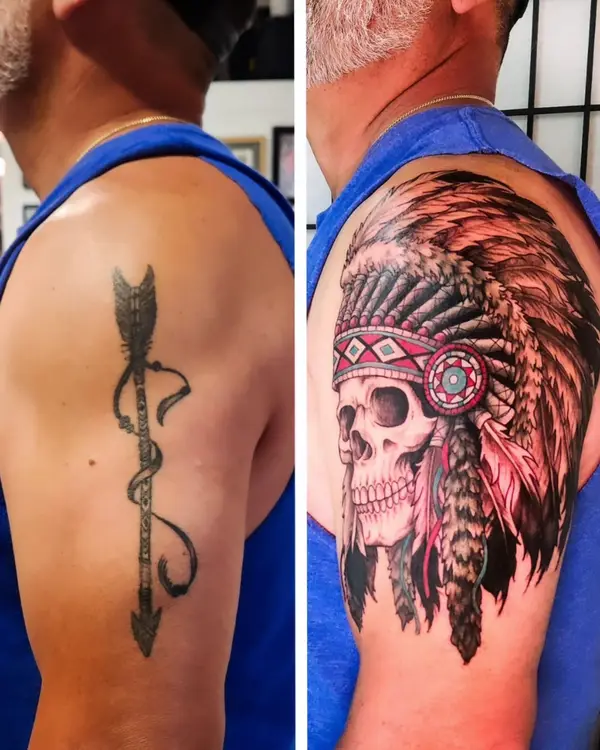 Cover-up before and after: an arrow tattoo on the upper arm covered by a skull wearing a feathered headdress.
