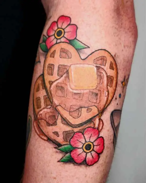 A color tattoo of stacked heart-shaped waffles with syrup and red flowers, by Amanda Boyd